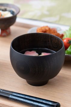 chopsticks and bowl of food on a wooden table