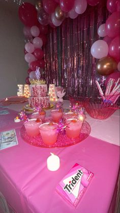 a pink table topped with drinks and balloons