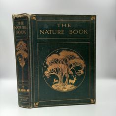 the nature book is sitting on a white surface with black and gold trimmings