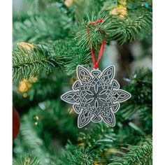 an ornament hanging from a christmas tree in the shape of a snowflake