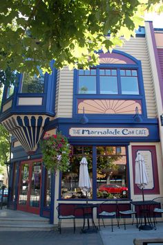 an outside view of a restaurant with tables and umbrellas