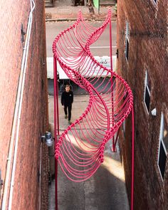 an overhead view of a person walking down a narrow alleyway between two brick buildings