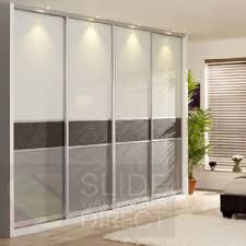 a living room filled with furniture and lots of white closet doors in front of a window