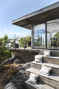 a wooden deck with chairs and pillows on it