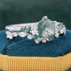 three stone ring sitting on top of a blue cushion