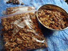 there is a bag of nuts next to a bowl of nuts on a blue table cloth