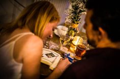 a man and woman sitting at a table with drinks