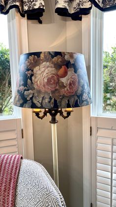 a lamp that is on top of a table next to a pillow and window sill