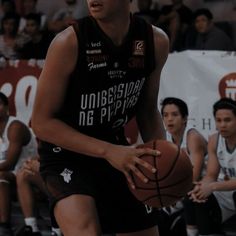 a basketball player dribbles the ball during a game with other players in the background