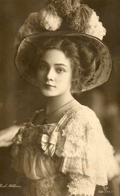 an old black and white photo of a woman wearing a hat