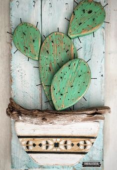 a wooden sign with three green cactuses on it