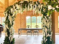 an open room with a piano and flowers on the wall, in front of a dining table