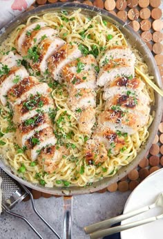 a pan filled with chicken and pasta on top of a table