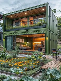 a green shipping container home surrounded by greenery