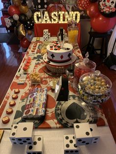 a casino themed birthday party with cake, candy and snacks on the table in front of it