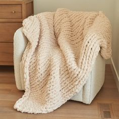 a white chair with a blanket on top of it