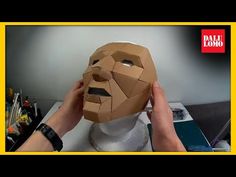 a person is making a mask out of cardboard