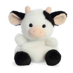 a small stuffed cow sitting up against a white background