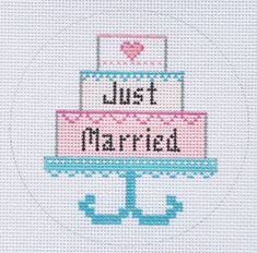 a cross stitch cake with the words just married on it's tiered layer