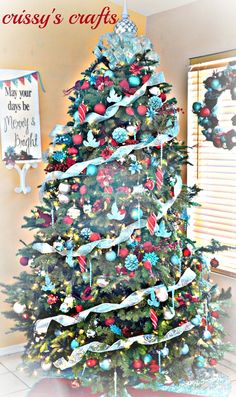 a decorated christmas tree in the corner of a room with blue and red ornaments on it