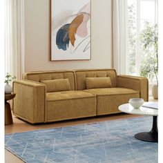 a living room filled with furniture and a painting on the wall over a blue rug