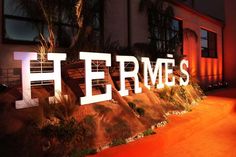 there is a sign that says hermes on the side of a building at night