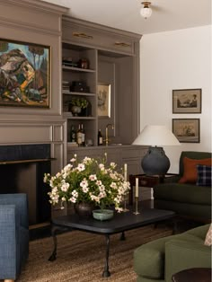 a living room filled with furniture and a fire place under a painting on the wall