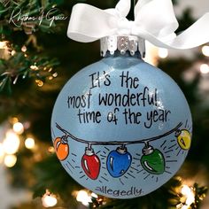 a blue ornament with words on it hanging from a christmas tree