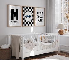 a baby's room with two posters hanging on the wall and a crib