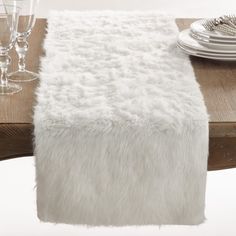 Take a detour from traditional decorating with this plush Faux Fur Table Runner, which adds beautiful warmth and texture to your tabletop. It will instantly elevate your table setting, giving it a glamorous-chic edge. Pair with metallic tableware for a contrasting effect between warm and cold, or simple, white dinnerware for a wintery look. Faux Fur Table Runner, Easter Dollar Tree Diy, Fur Table Runner, Fur Table, White Table Cover, Fur Design, White Dinnerware, Easter Decorations Dollar Store, White Faux Fur