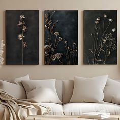 three floral paintings hang on the wall in a living room