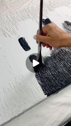 a person is using a brush to paint a piece of art