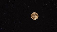 the full moon is shining brightly in the dark night sky with stars all around it