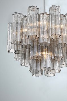 a chandelier made out of clear glass tubes hanging from the ceiling in a room