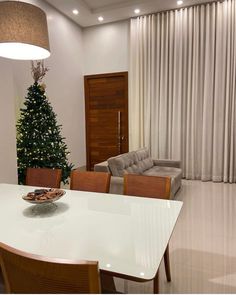 a dining room table with chairs and a christmas tree in the corner next to it