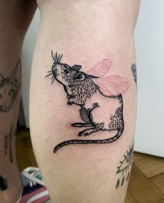 a small mouse tattoo on the leg