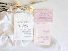 the wedding stationery is laid out next to some flowers