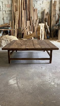 a wooden table sitting in front of a pile of wood