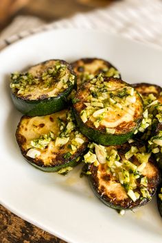 some zucchini stuffed with cheese and other toppings on a white platter