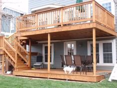 a dog is standing on the back deck of a house with stairs leading up to it