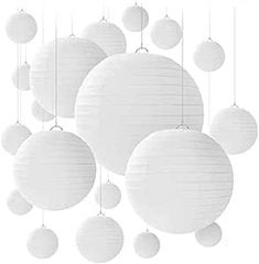 white paper lanterns hanging from strings on the ceiling in front of a white background with circles