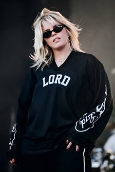 a woman with blonde hair wearing sunglasses and a black shirt