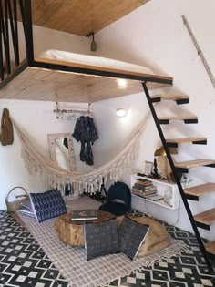 there is a hammock bed in the corner of this living room with stairs