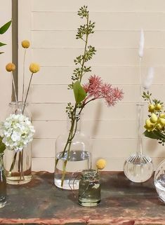 several vases with flowers in them sitting on a table