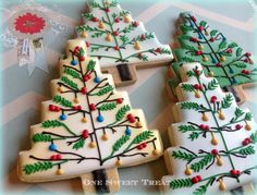 three decorated christmas trees are shown on cookies