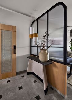 a vase with some flowers in it sitting on a counter next to a glass door