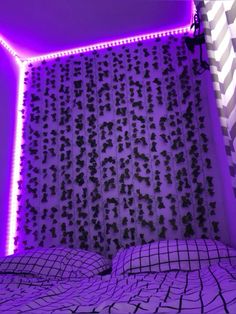 a bed with purple lights in the corner next to a wall that has black and white checkered sheets on it