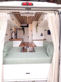 the inside of a camper with a couch and table in it's back