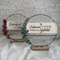 two wooden signs with vines and lights on them sitting on a white fur covered floor