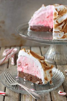 a piece of cake on a glass plate with a fork and candy canes around it